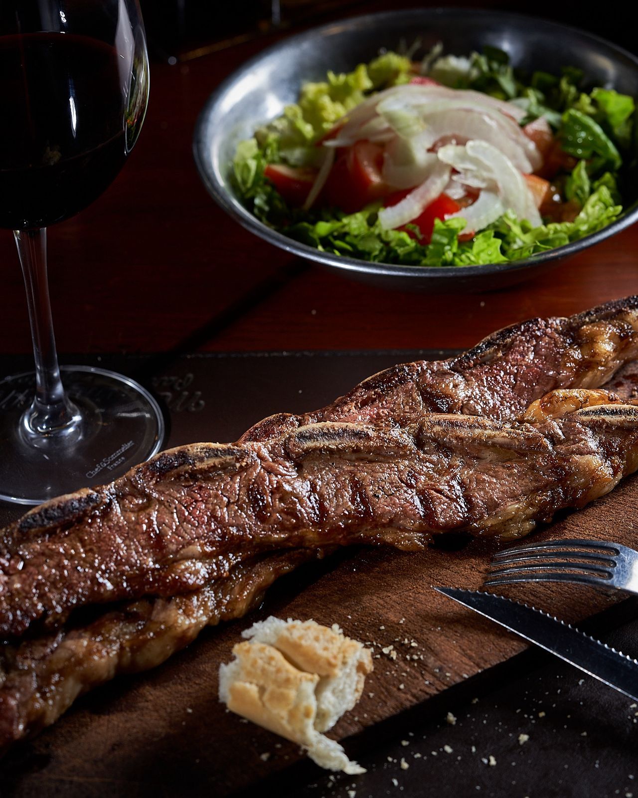 Tira de asado con ensalada y vino